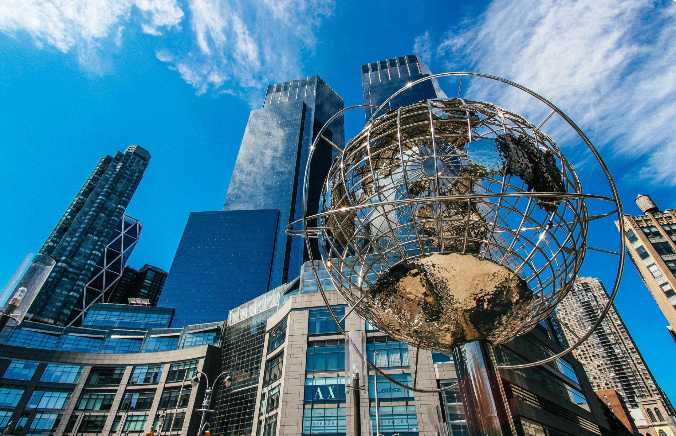 Globe sculpture in front of city skyscrapers, representing India's role in the global economy